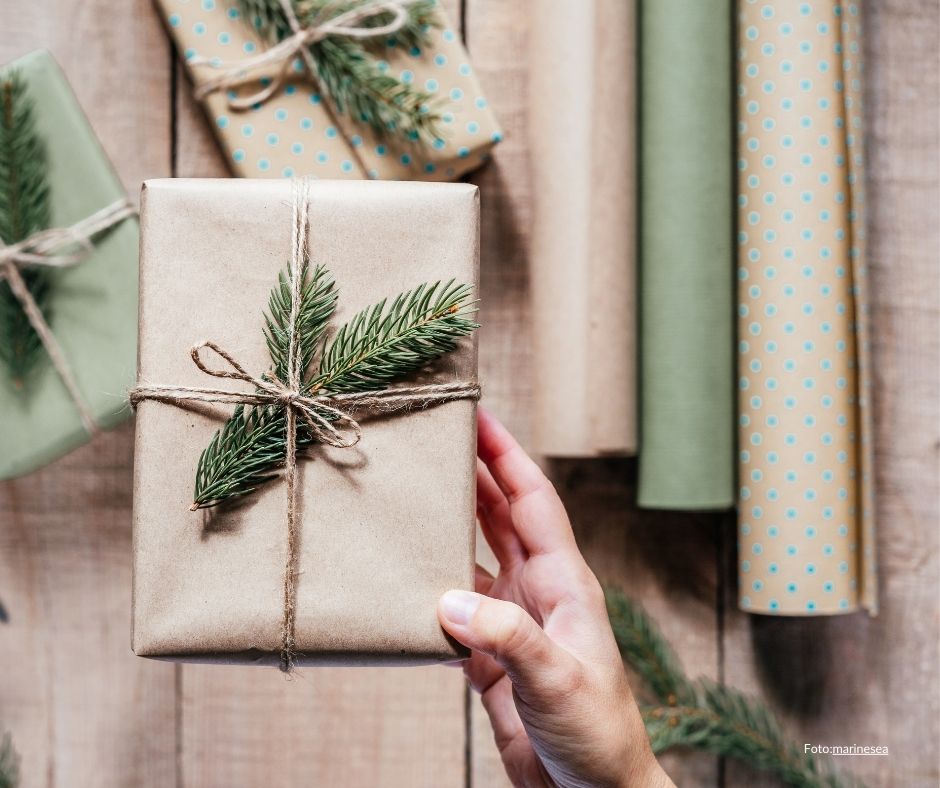 Gave i gråpapir pyntet med granbar og kongle. Foto canva Marinesea